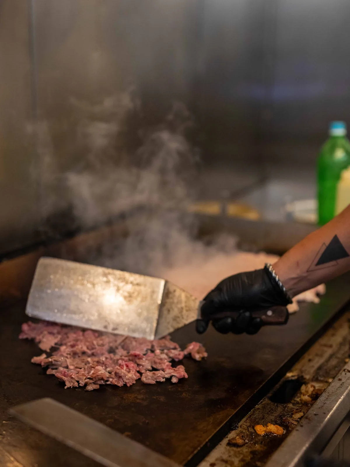 Steak sizzling on the flat-top grill in the Las Flores kitchen